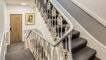 A staircase with ornate metal railings and carpeted steps.