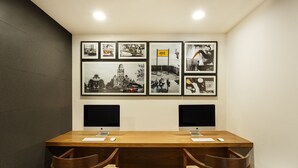 A conference room with a wooden table, two monitors, and framed pictures on the wall. - Ginger Noida Sector 63 (Noida)