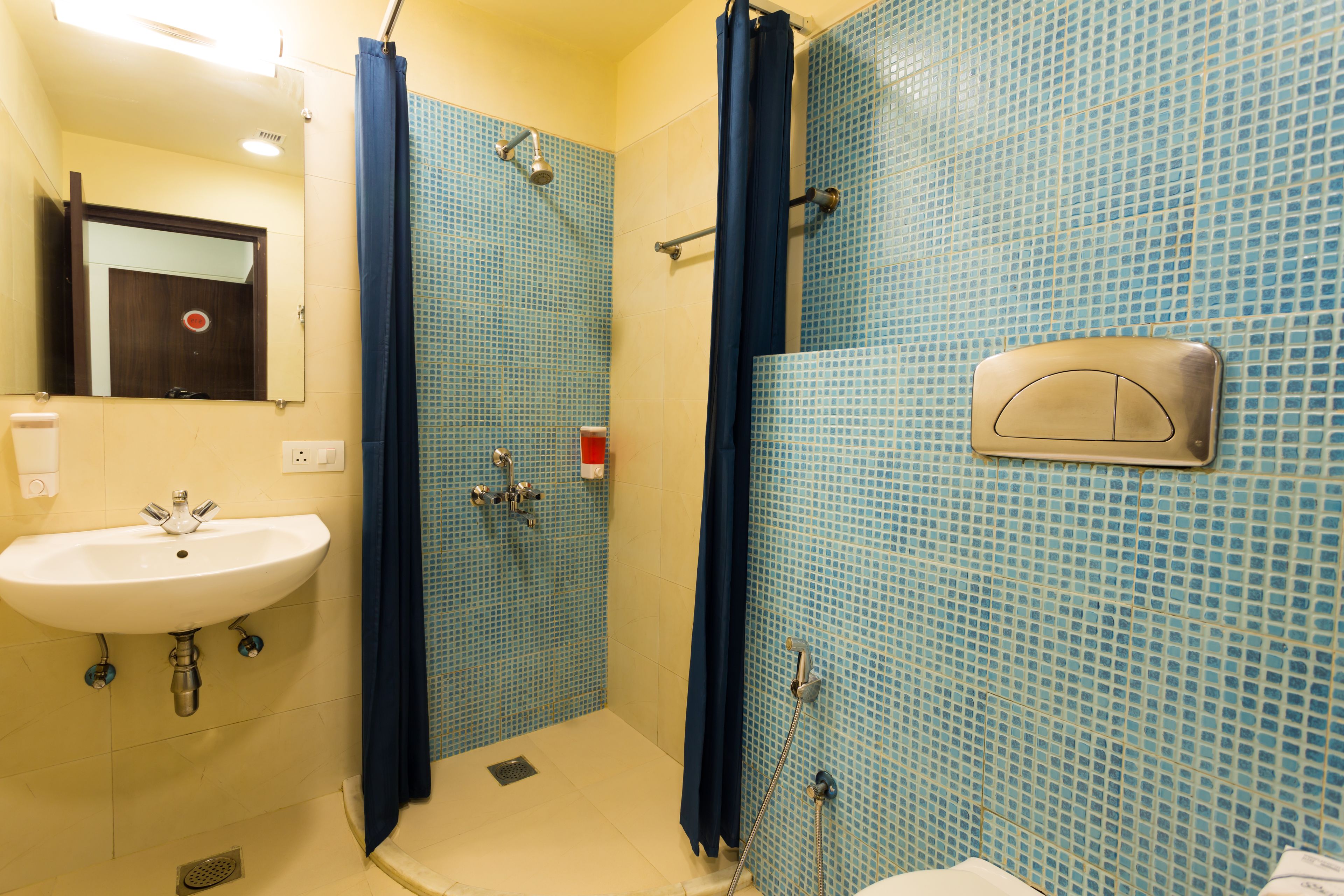 Un baño con lavamanos, ducha y espejo.