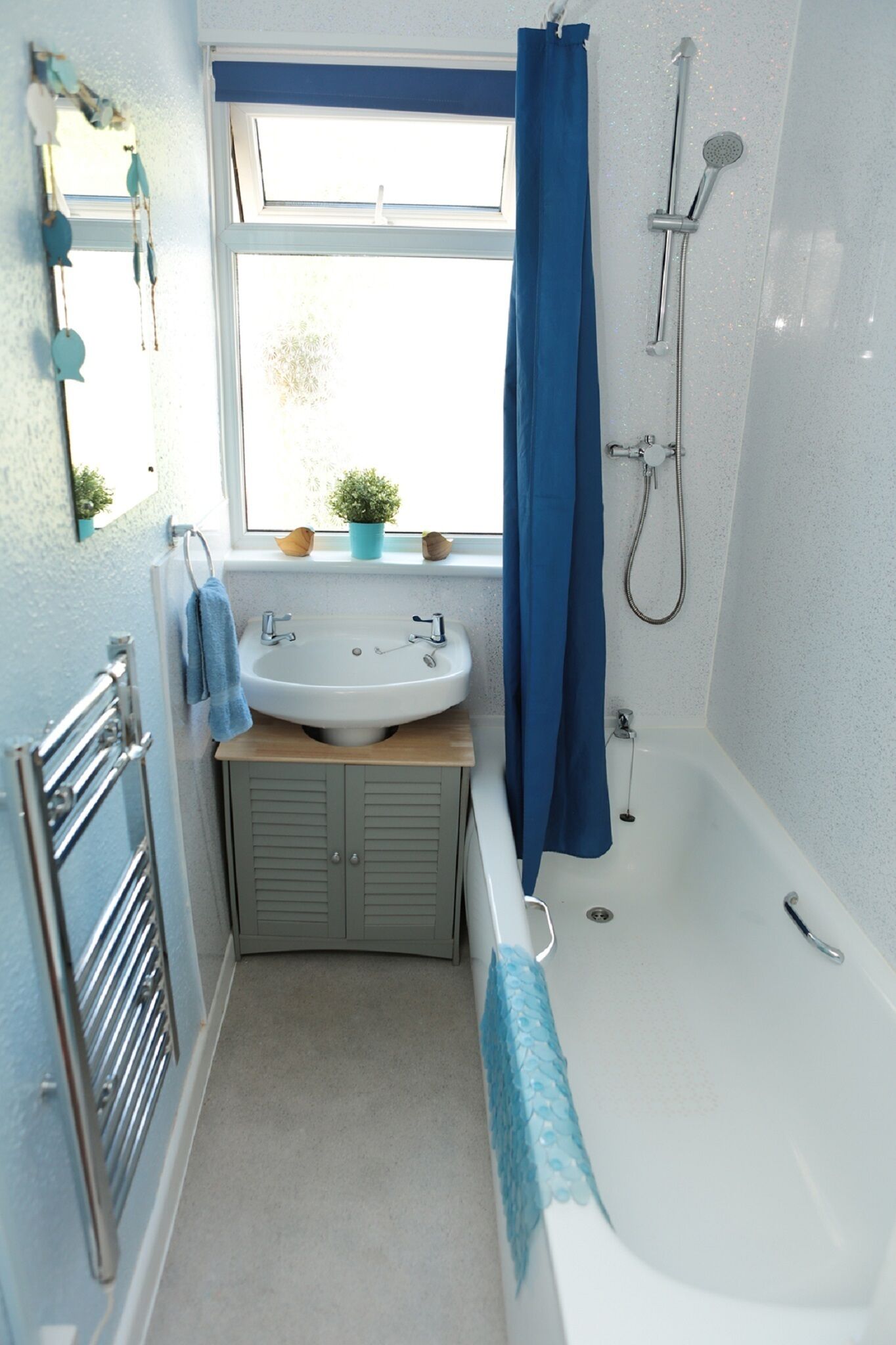 Ein Badezimmer mit einer weißen Badewanne, einem Waschbecken und einer Dusche.