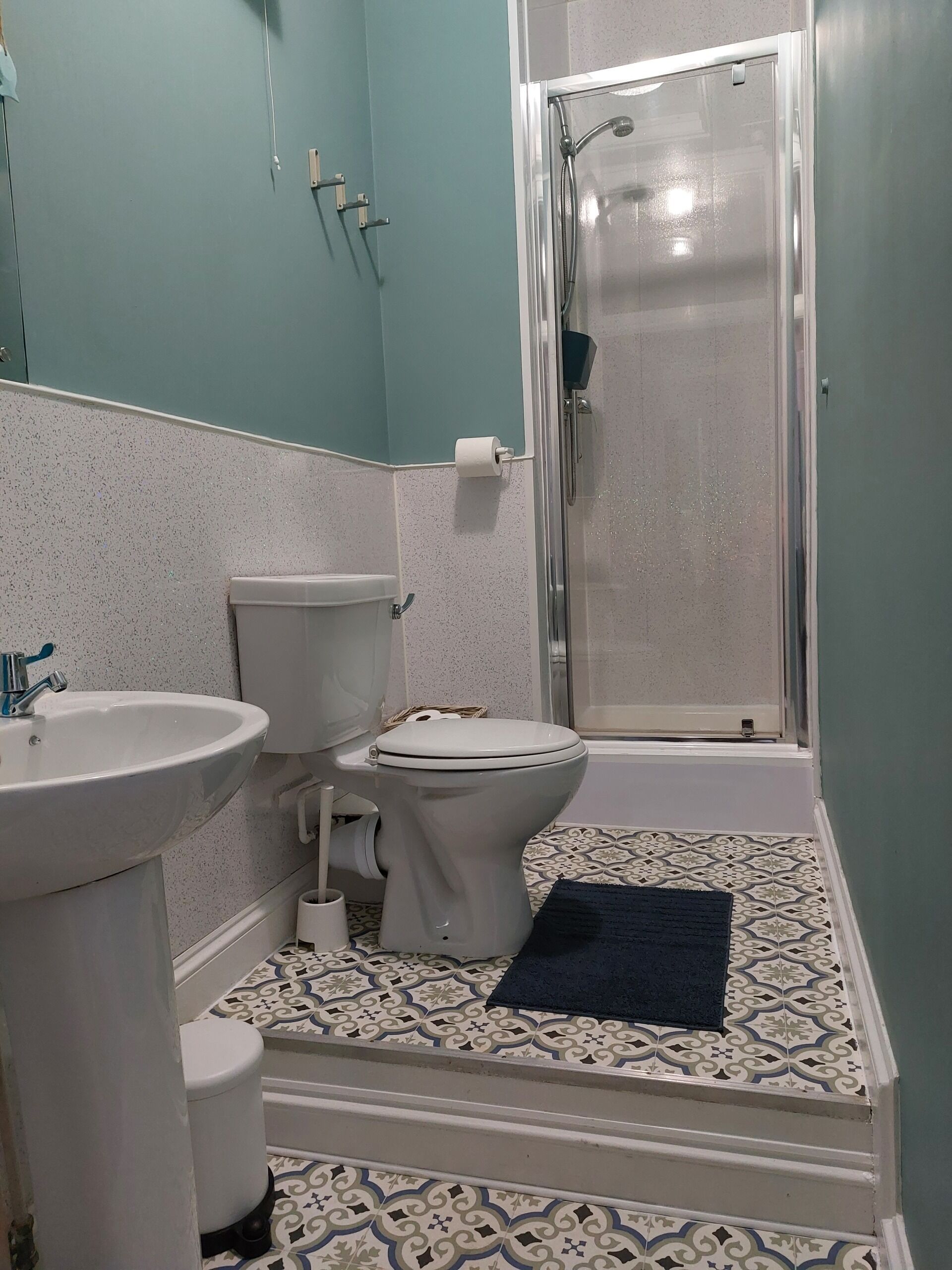 Un baño con inodoro, lavamanos y ducha.