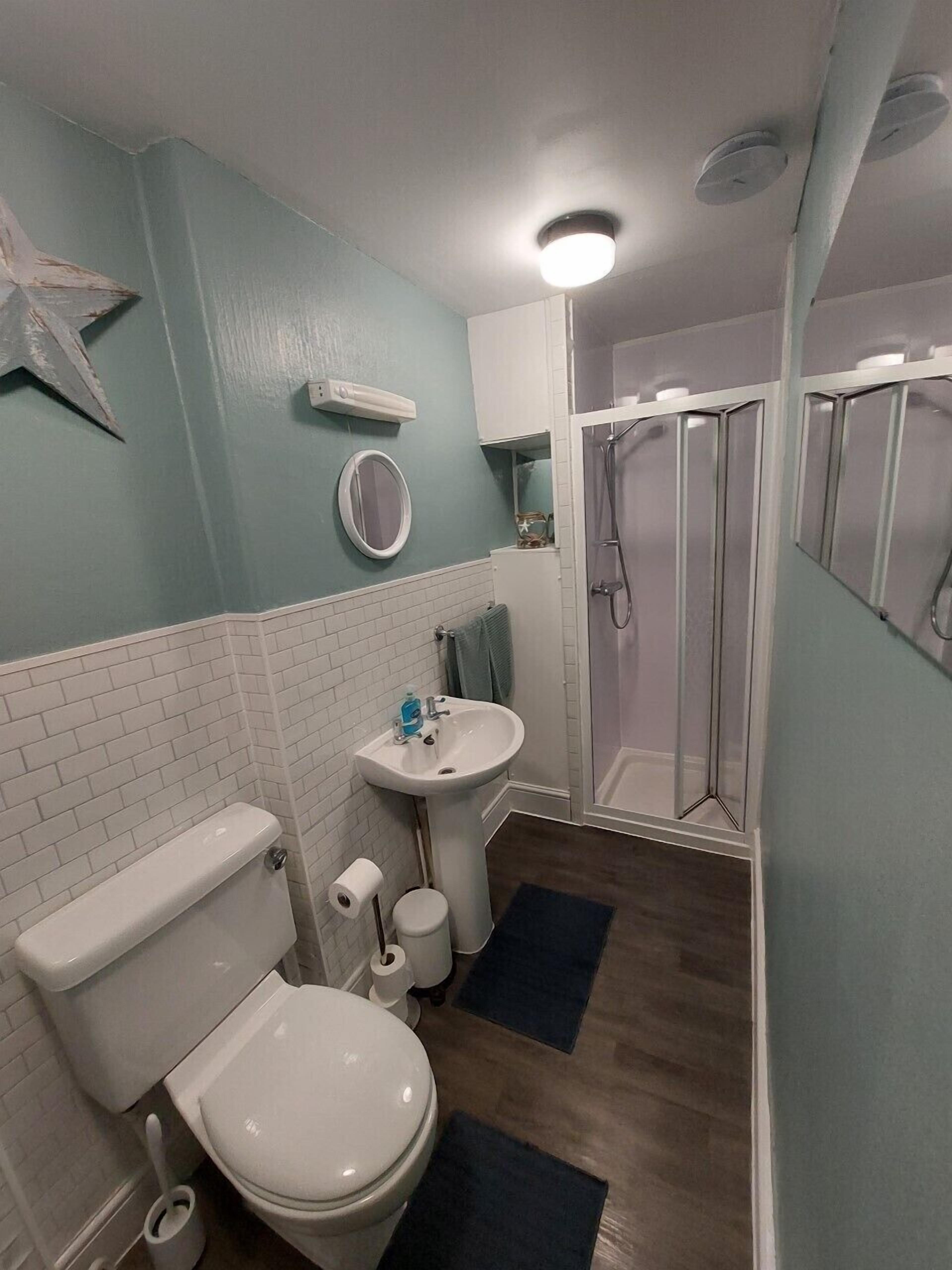 A bathroom with a toilet, sink, and shower.