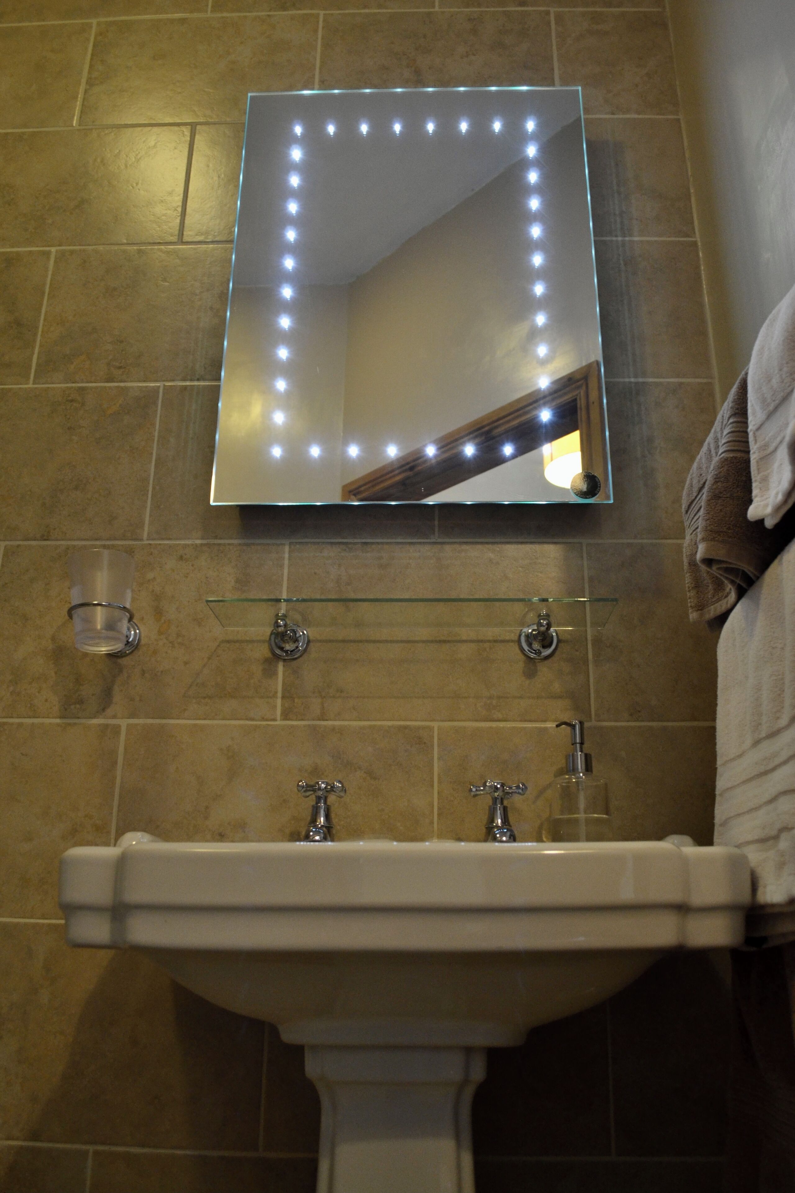 A bathroom with a sink, mirror, and towel rack.