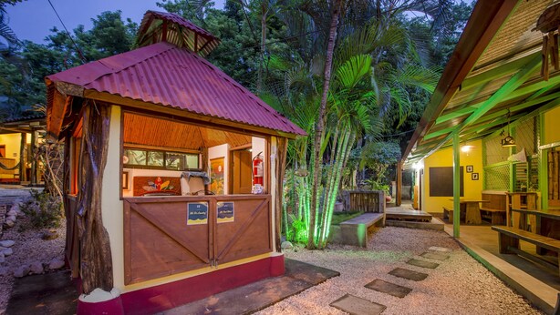 A small outdoor kiosk with a red roof, wooden counter, and a sign indicating it is a restaurant. - Indra Inn (Cabo Velas)