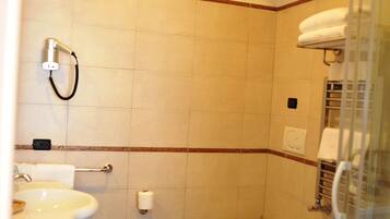 Une salle de bain équipée d’un lavabo, de toilettes, d’un bidet et d’un espace douche.