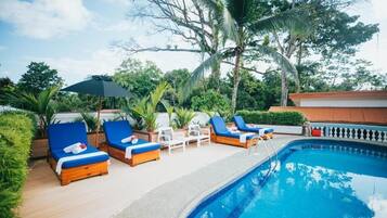 Relax by the serene pool surrounded by lush greenery and shaded seating areas.