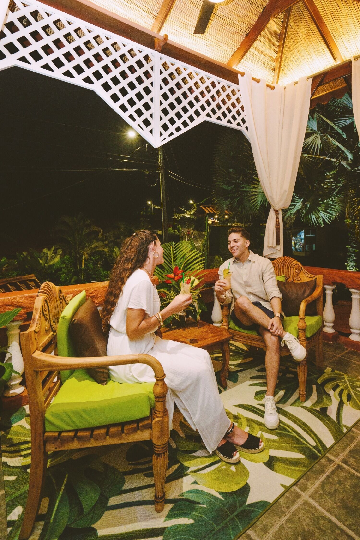 Eine hölzerne Bank mit einem grünen Kissen, ein Holzstuhl und ein Tisch mit einer Pflanze.