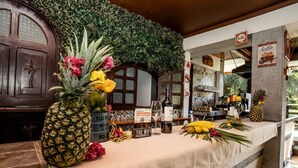 A bar area with a tropical theme, including a pineapple centerpiece, flowers, and a sign indicating wifi password. - Hotel Villabosque Eco Boutique (Quepos)
