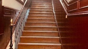 A wooden staircase with a handrail and balusters, leading to an upper floor. - Hostal Rias Bajas (Madrid)