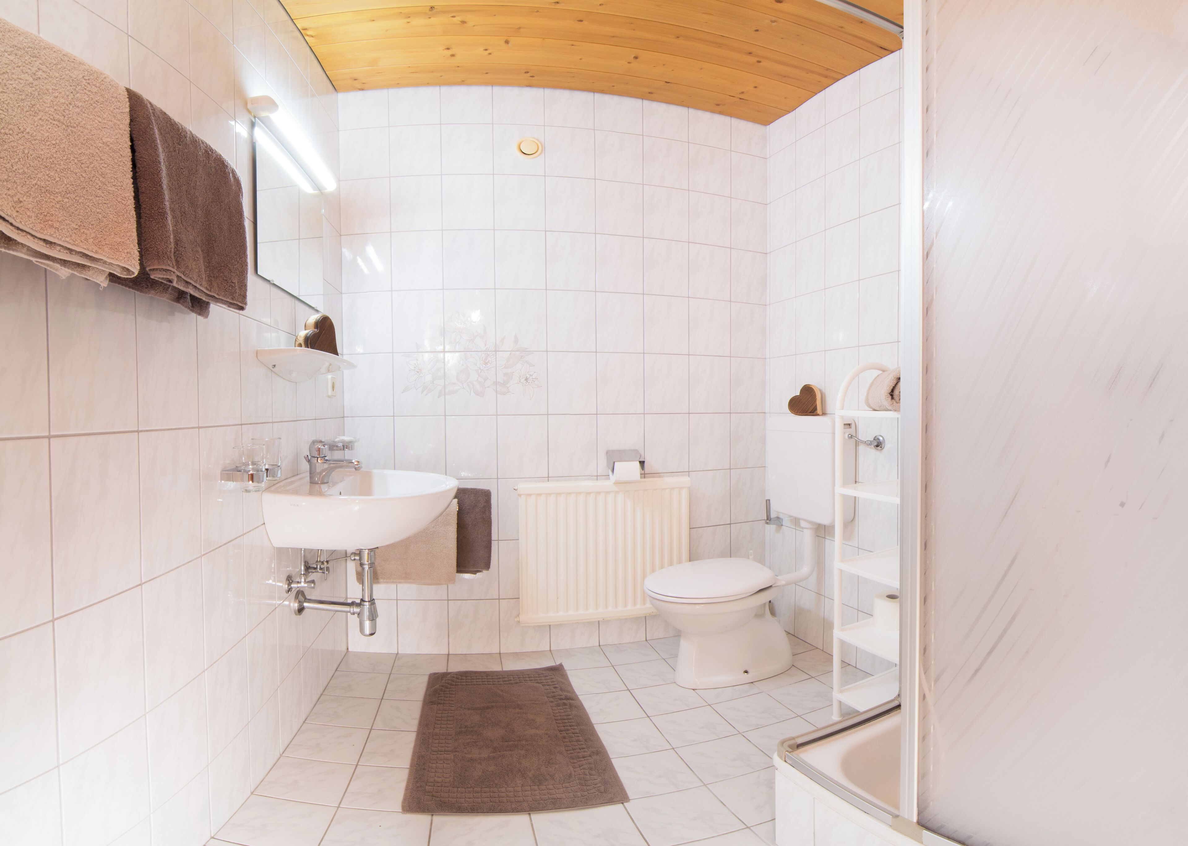 Un baño con lavamanos, inodoro y ducha.