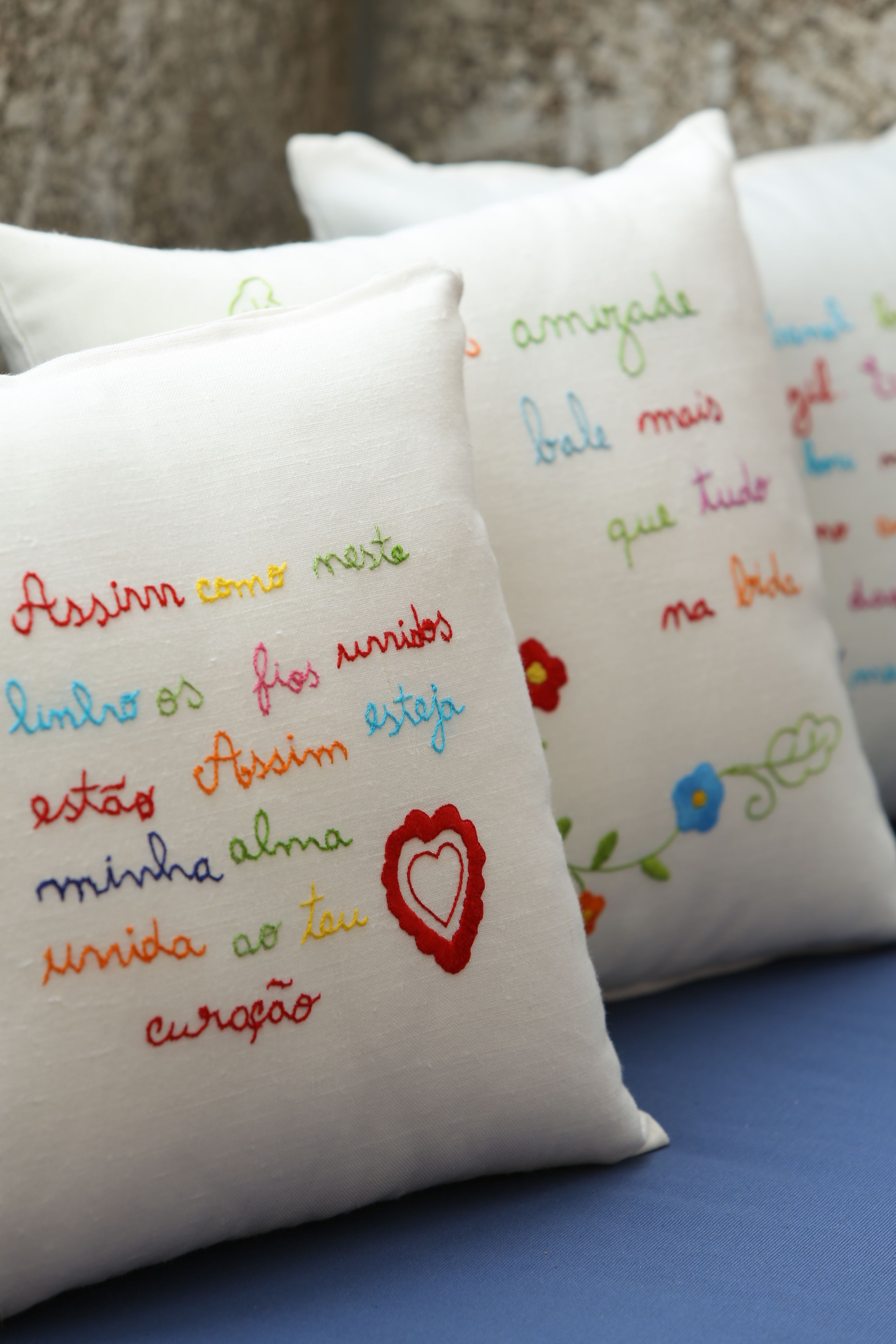 Pillows with embroidered text and a red heart design.