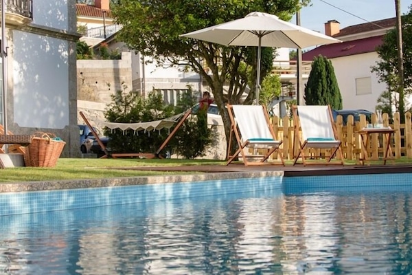 Alberca al aire libre, sombrillas en la alberca y camastros