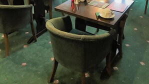 Uma área de refeições com mesas e cadeiras, algumas com cardápios e acompanhamentos.