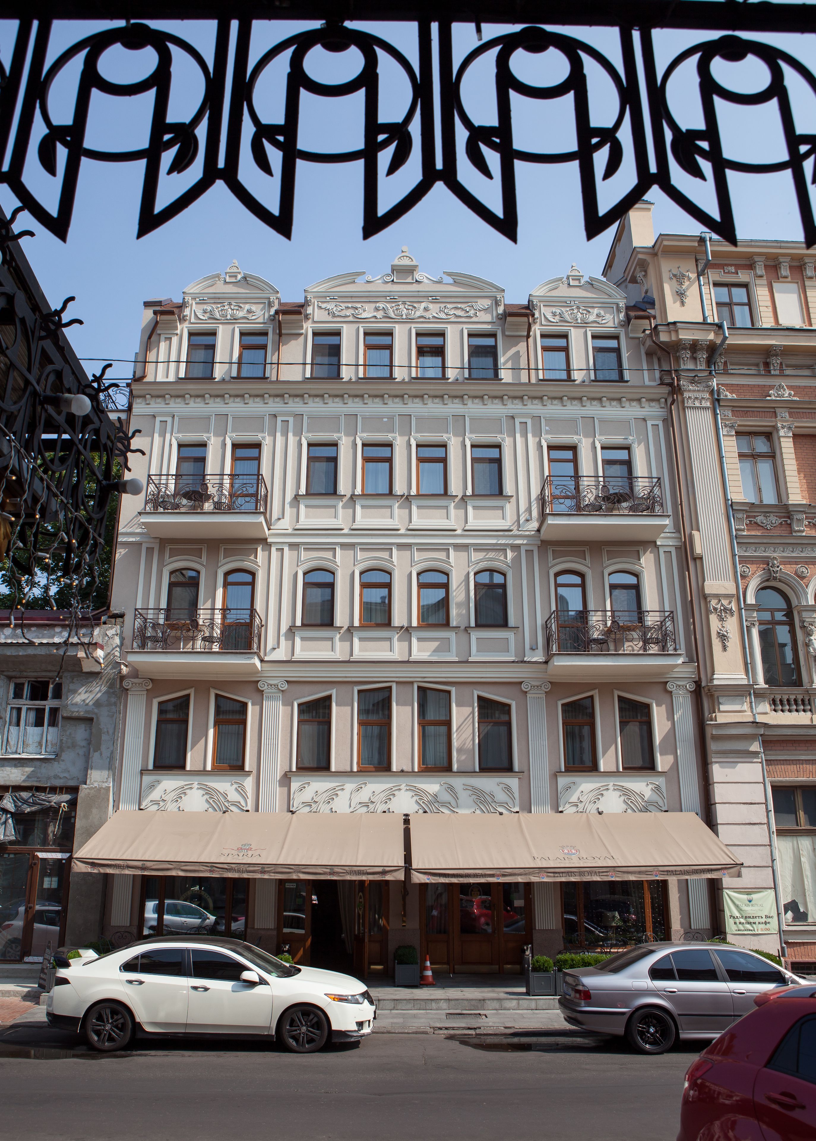 A multi-story building with ornate architectural details, including balconies with wrought iron railings and a series of windows.