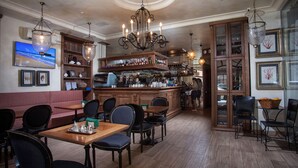 Una zona de bar con muebles de madera, un televisor y una estantería.