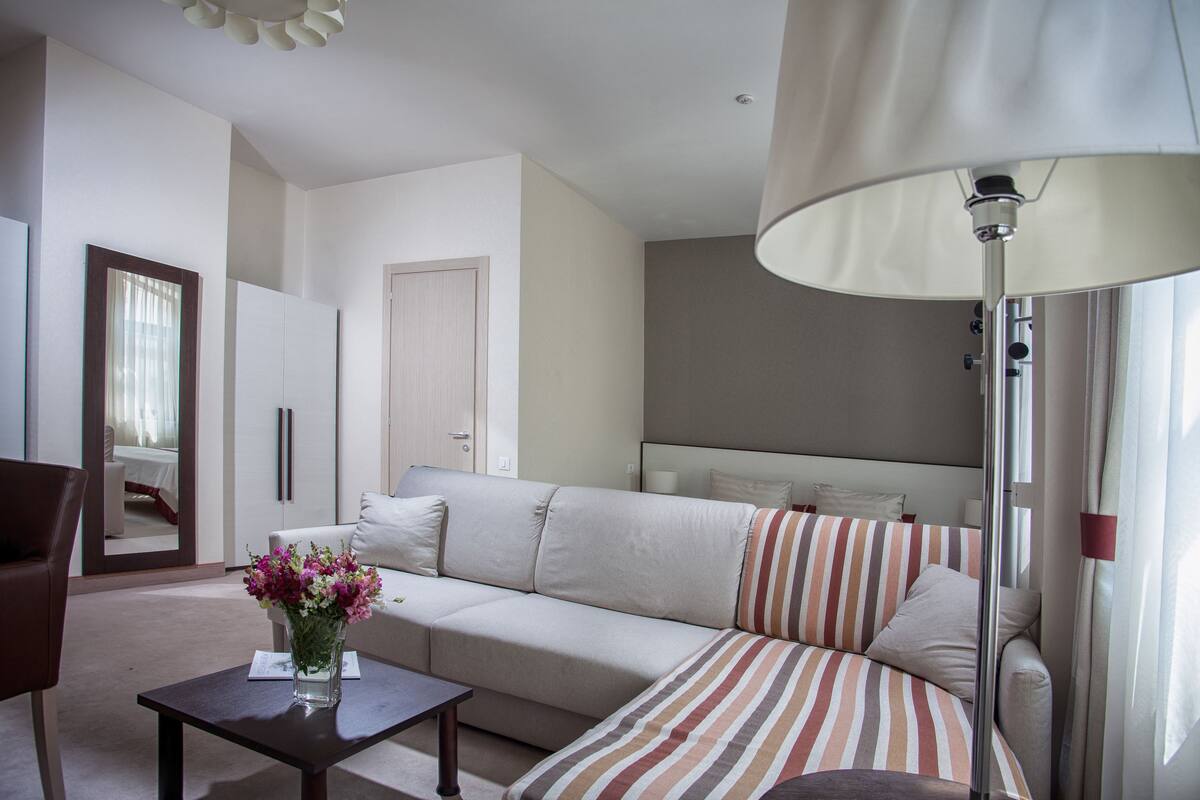 A modern living room with a sofa, a coffee table, and a lamp.