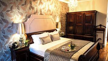 A neatly made bed with a quilted bedspread, a bedside table with a lamp, and a decorative tray with flowers.