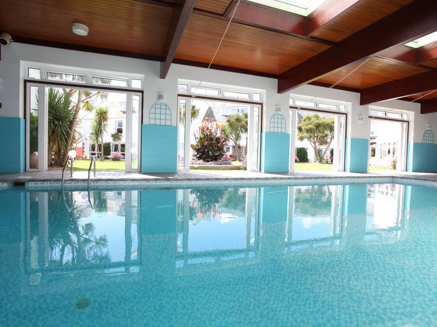 Una piscina techada, sillones reclinables de piscina