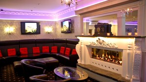 A modern lounge with a fireplace, comfortable seating, and ambient lighting.