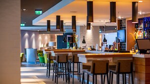 A modern bar area with high stools, a bar counter, and pendant lighting.