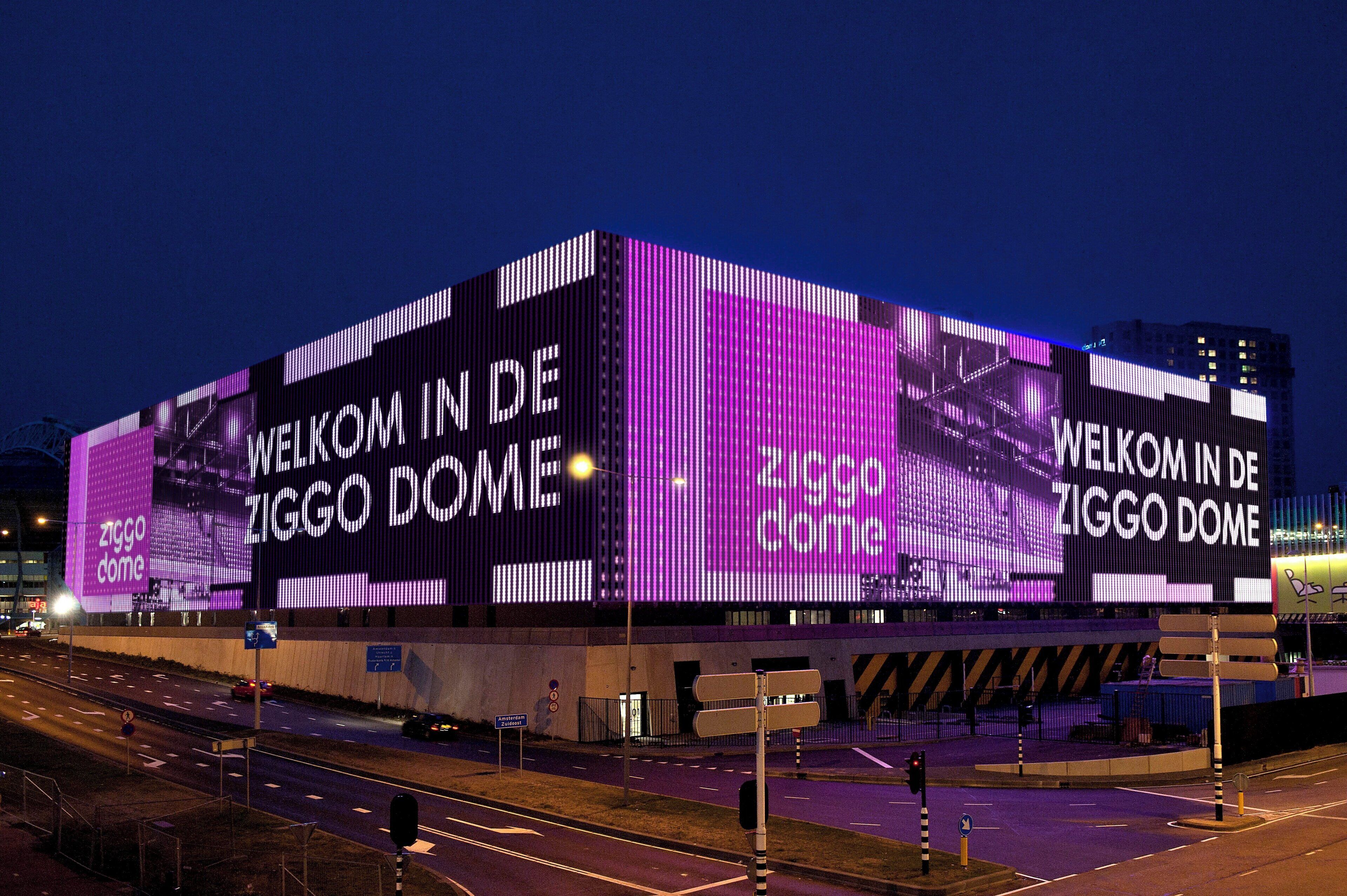 A large building with illuminated signage welcoming visitors to the Ziggo Dome.