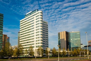 A modern hotel with a curved facade, multiple floors, and a glass exterior. - Holiday Inn Amsterdam - Arena Towers by IHG (Amsterdam)