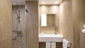 A modern bathroom with a shower, sink, and mirror.