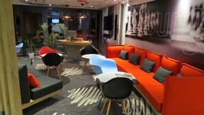 A modern lounge area with a sofa, chairs, and a small table.