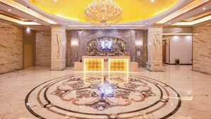 A luxurious lobby with a grand chandelier, marble flooring, and a central decorative wall. - Regan International Hotel (Wuxi)