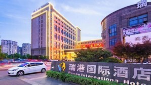 A hotel entrance with signage in multiple languages, including English. - Regan International Hotel (Wuxi)