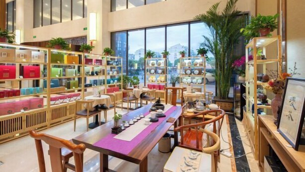 A spacious interior with high ceilings, large windows, and a variety of seating arrangements. - Regan International Hotel (Wuxi)