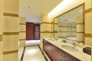 A modern bathroom with two sinks, a large mirror, and a vanity cabinet. - Regan International Hotel (Wuxi)