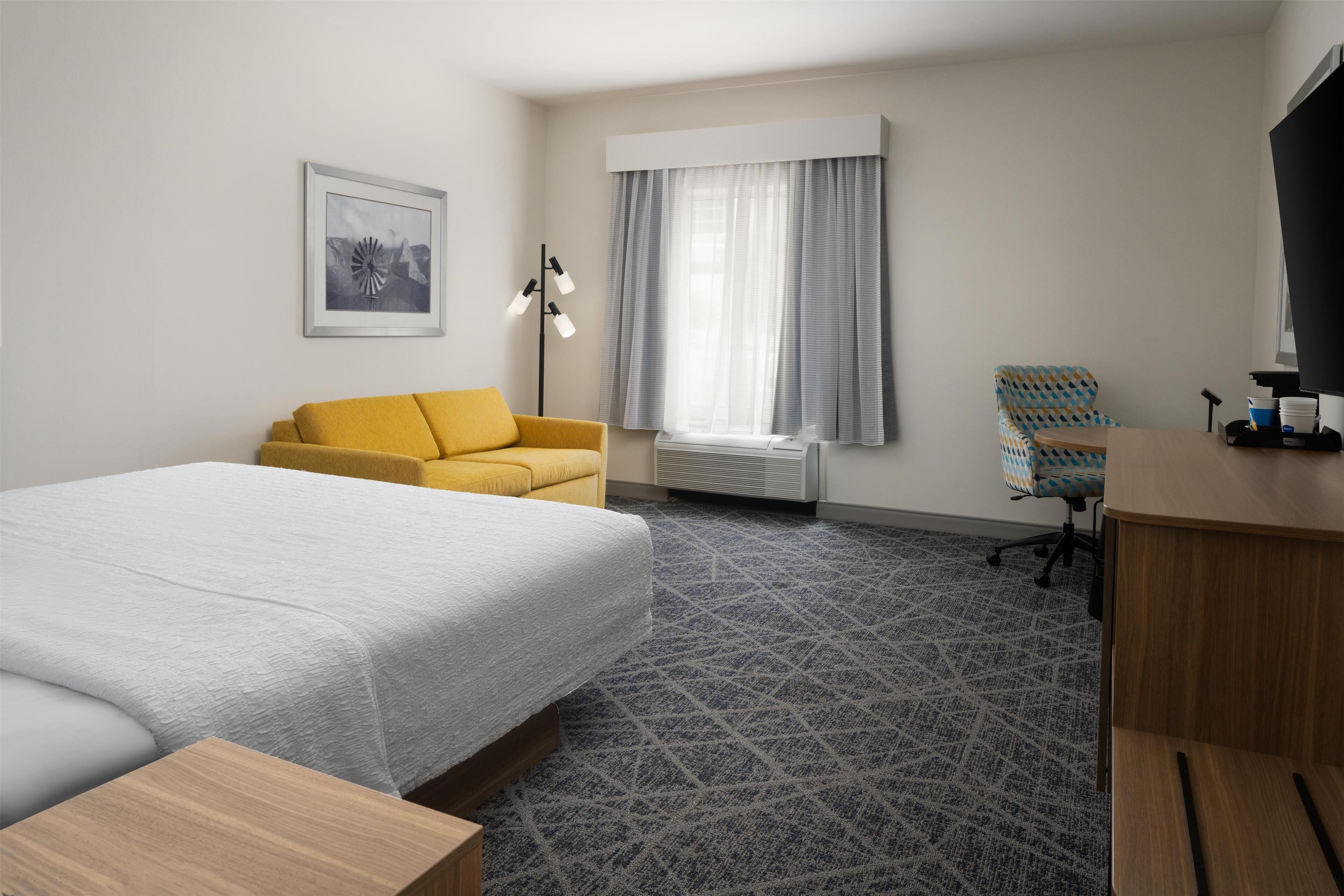 Habitación, 1 cama King size, refrigerador y microondas | Área de sala de estar | Televisión de pantalla plana de 42 pulgadas con canales por cable 