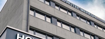 Un moderno edificio de hotel con un letrero que dice "HOTEL MERKUR".