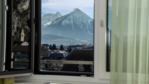 Una ventana con vistas a una cordillera y un pueblo en la falda.