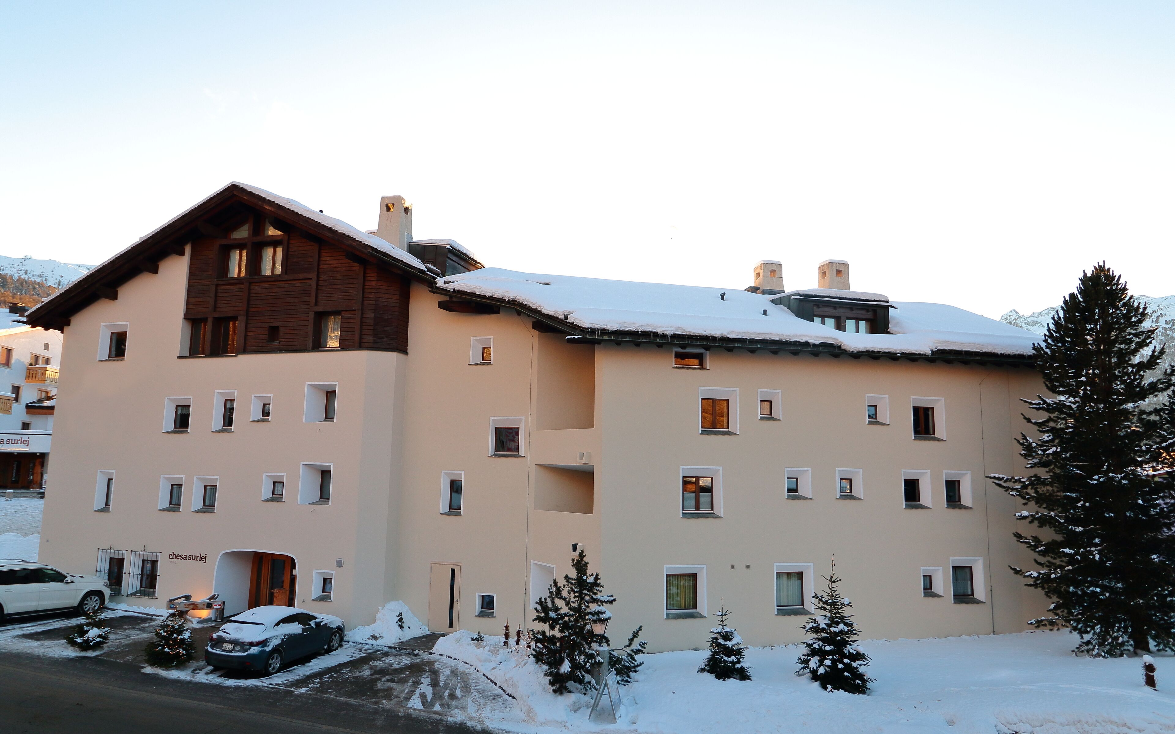 Ein mehrstöckiges Gebäude mit schneebedecktem Dach und mehreren Fenstern.