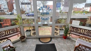 A hotel entrance with a glass door, a sign reading "VACANCIES", and a view of the street outside. - Serena Court Hotel (Skegness)