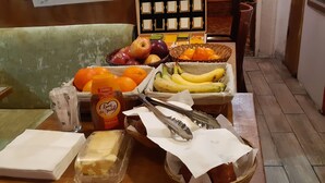 Una mesa con diversos alimentos, incluyendo frutas, queso y salsas.