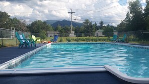 A rectangular swimming pool with a blue interior, surrounded by a chain-link fence. - Carlson's Lodge (Twin Mountain)