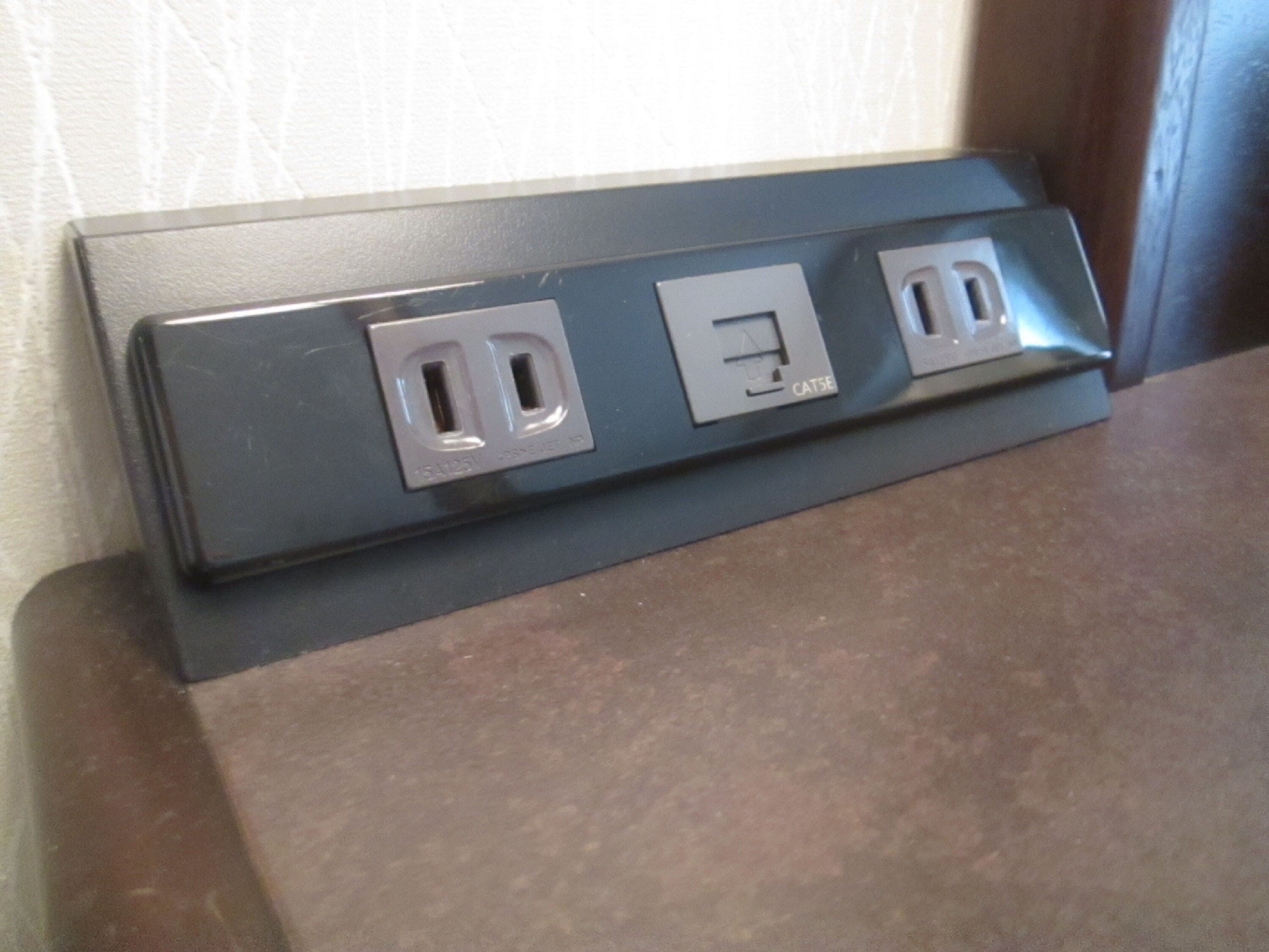 Un enchufe empotrado en la pared con dos tomas de corriente y un puerto USB.