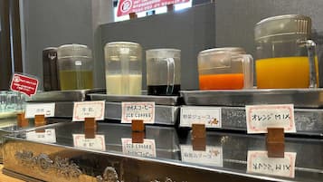 Dispensador de bebidas con diversas opciones, incluyendo café helado y una mezcla, con etiquetas en japonés.