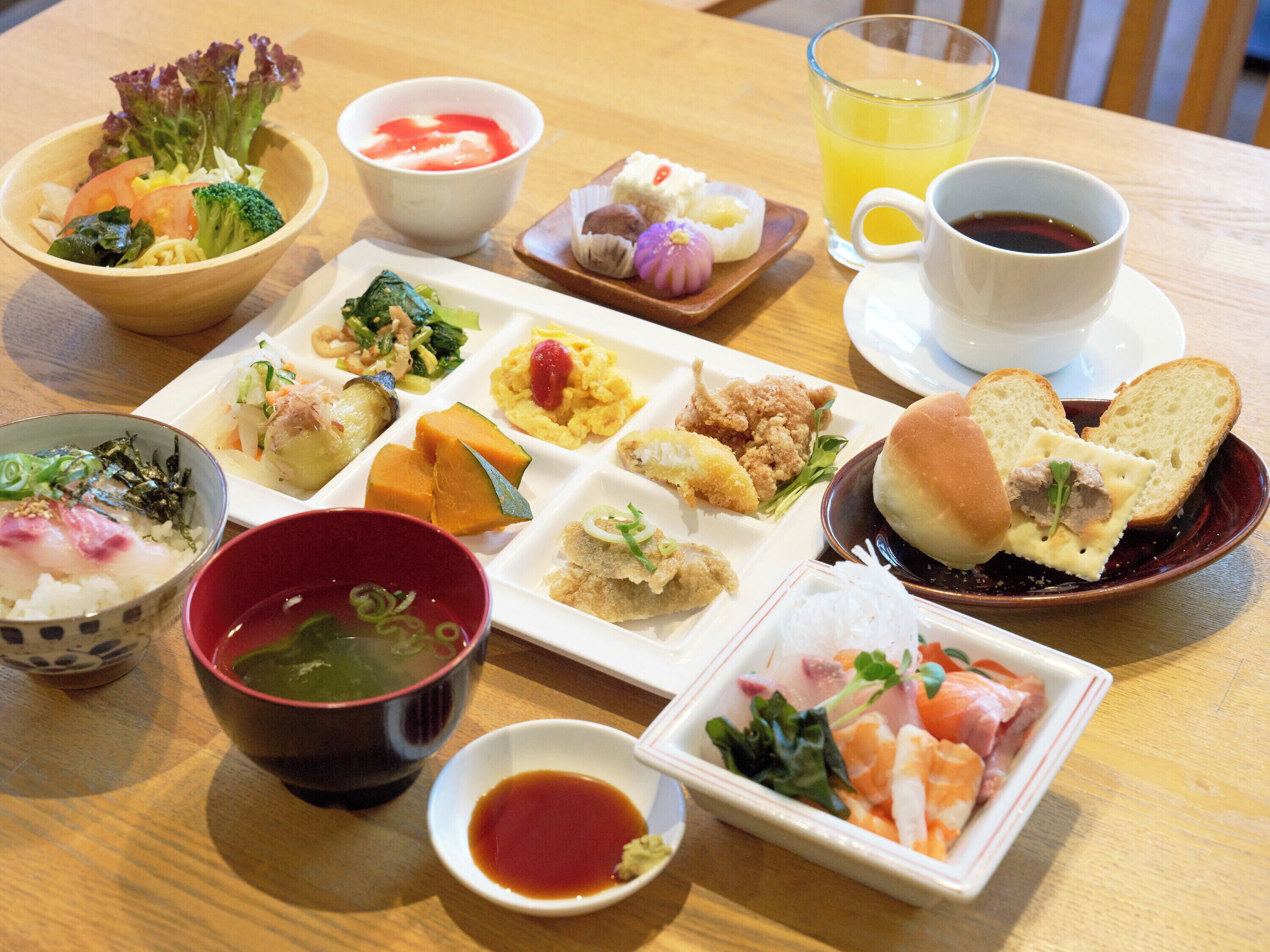A variety of dishes including sushi, sashimi, and a bowl of soup.