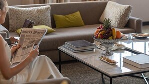 A living room with a sofa, a coffee table, and a fruit bowl. - Hôtel Volubilis (Fes)