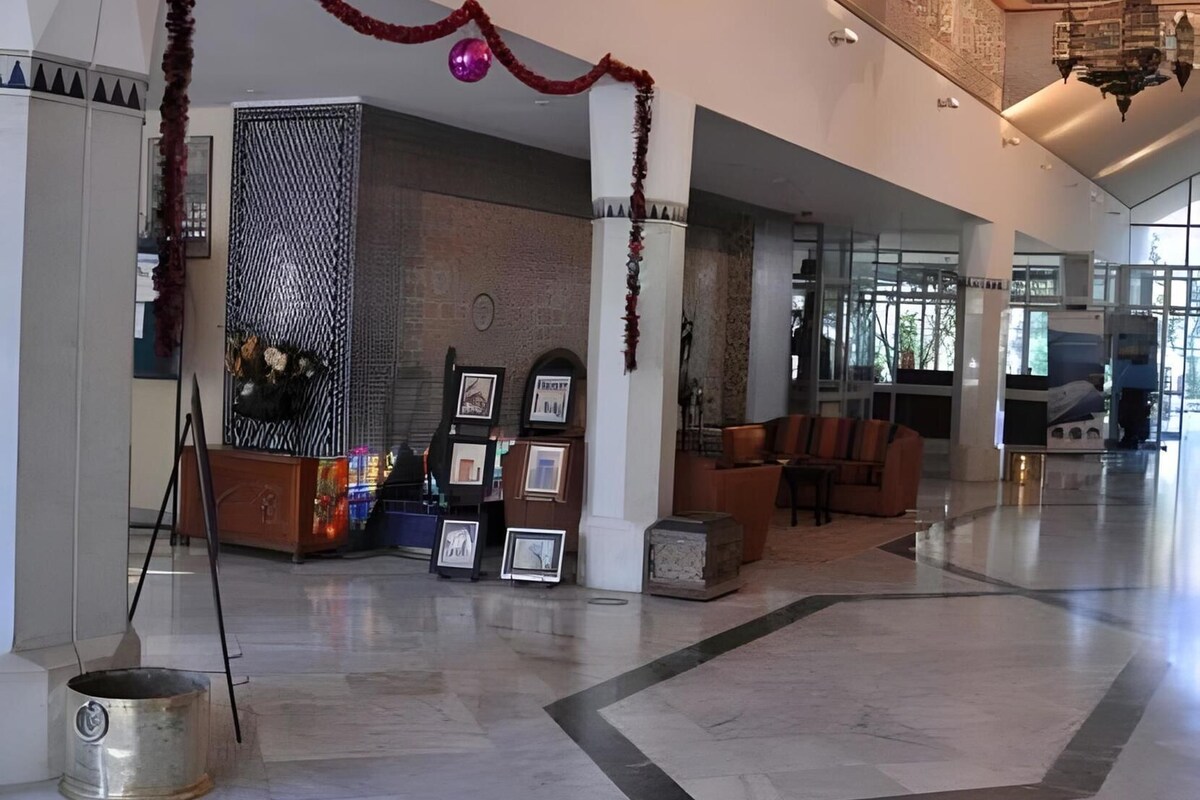 A spacious lobby with a reception desk, seating area, and a decorative wall.