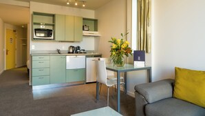 A compact living space with a kitchenette, a dining area, and a sofa.