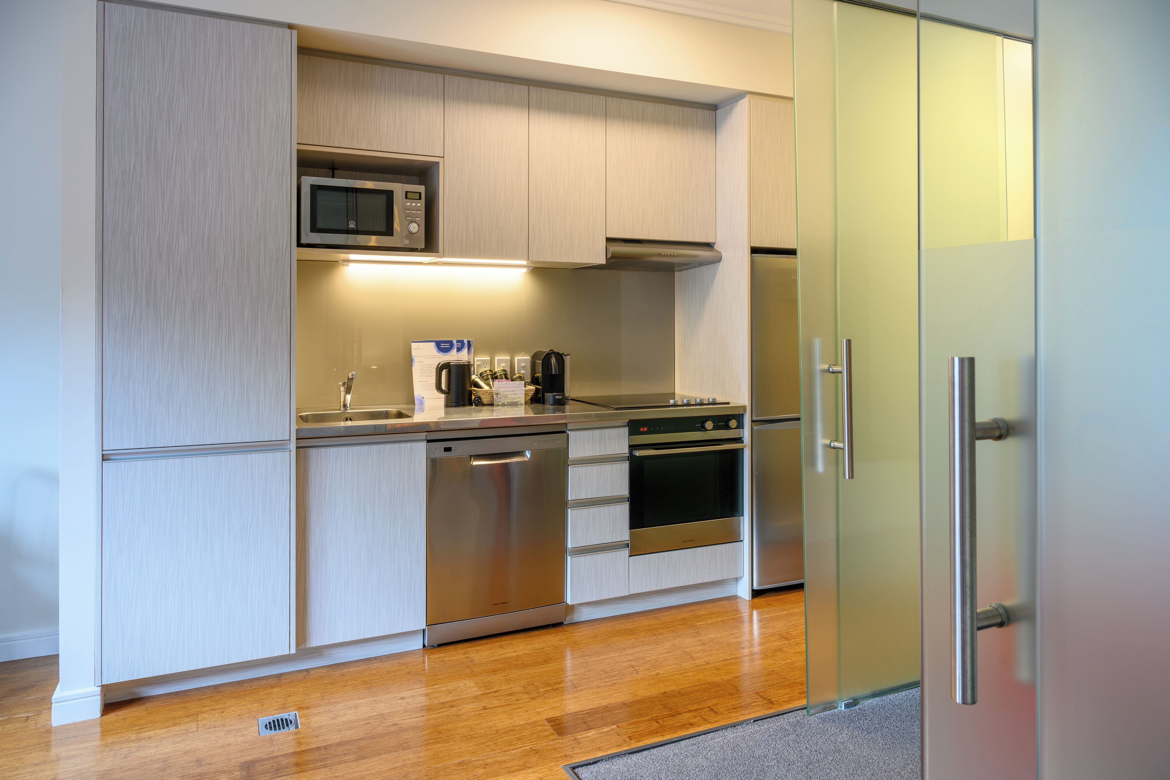 A modern kitchen with stainless steel appliances, a microwave, oven, and dishwasher.