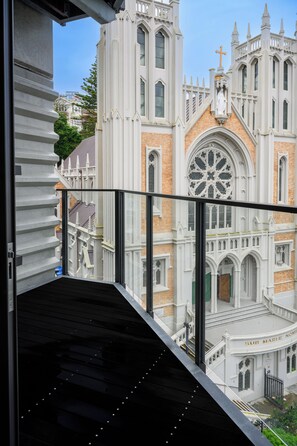 A view from a balcony overlooking a historic church with a large rose window and a statue on top. - Boulcott Suites (Wellington)