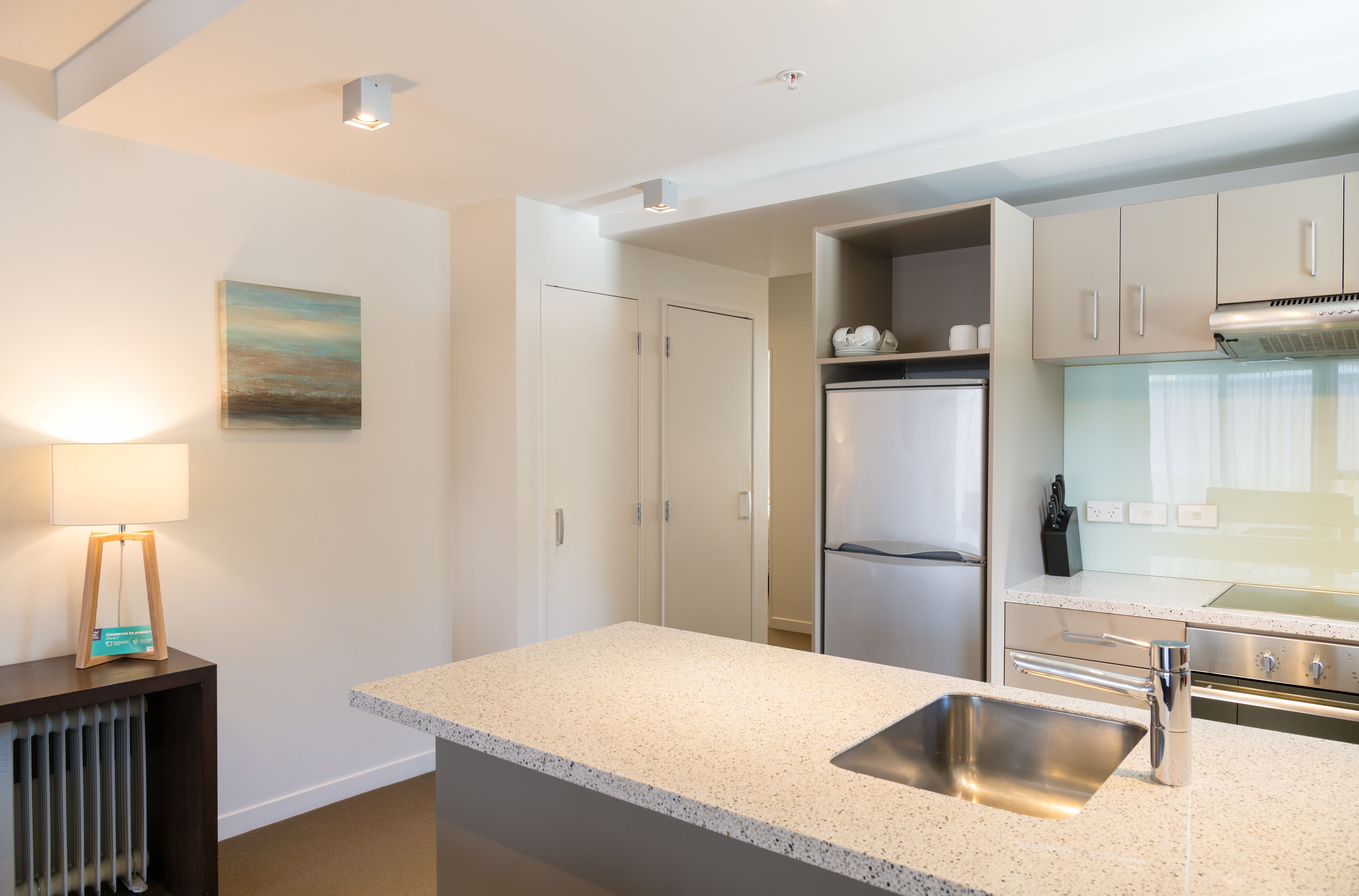 A modern kitchen with a granite countertop, stainless steel sink, and a built-in oven.