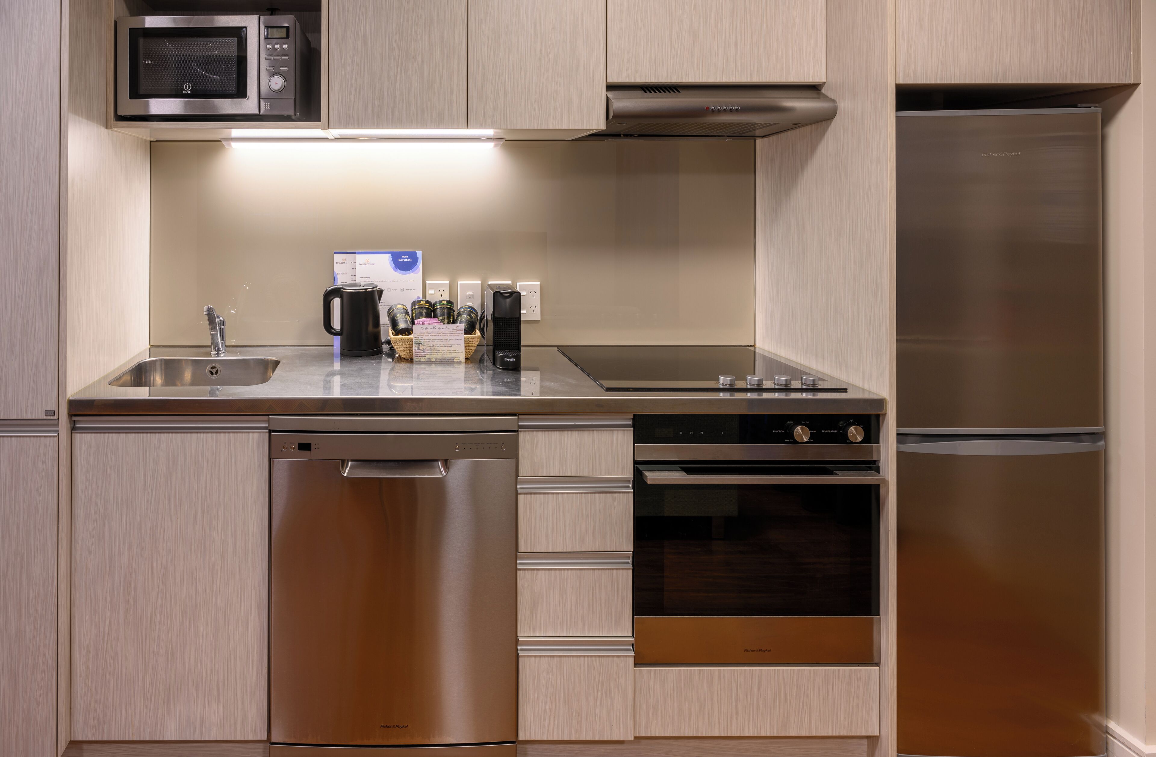A modern kitchen with stainless steel appliances, including a dishwasher, oven, and refrigerator.