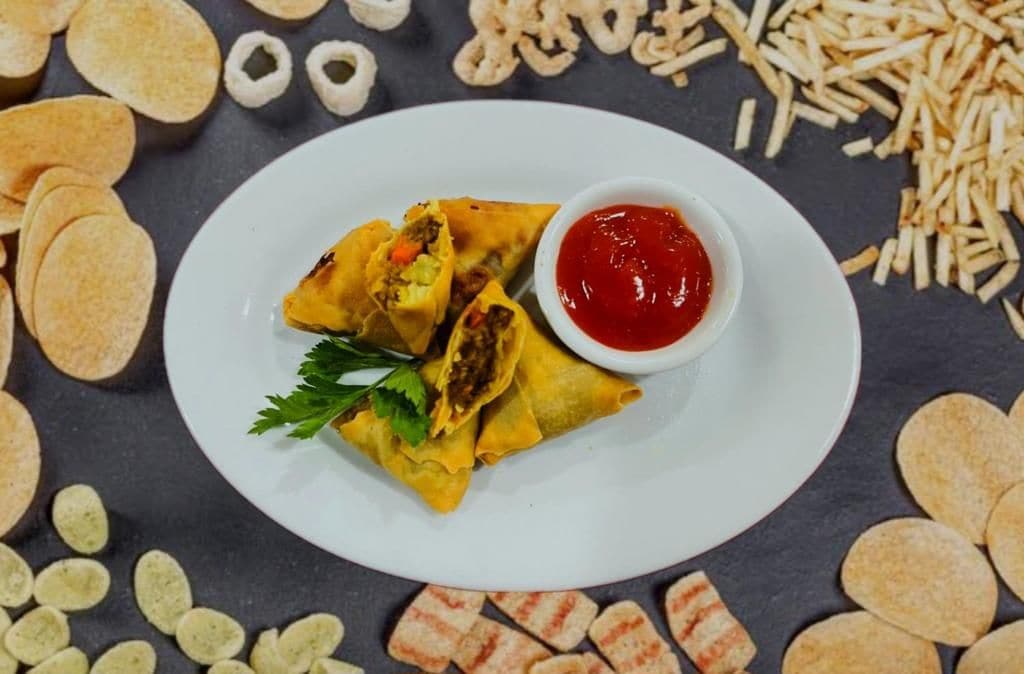 Une assiette de nourriture accompagnée d’une sauce et de diverses collations.